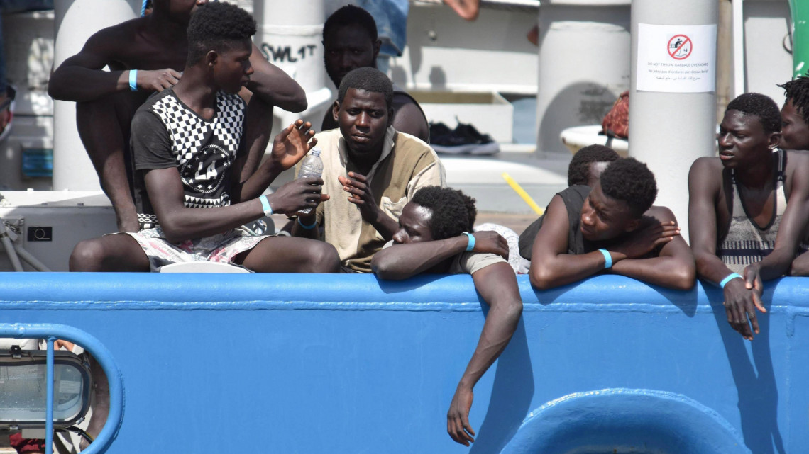 Catania, 2017. július 1.Ilegális bevándorlók az EU határvédelmi ügynöksége, a Frontex svéd felségjelű hajójának fedélzetén a szicíliai Catania kikötőjében 2017. július 1-jén. A mintegy 650 hajótörött migránst a Földközi-tengeren, a líbiai partok közelében vették a fedélzetre, kilenc vízbe fúlt társuk holttestével együtt. (MTI/EPA/Orietta Scardino)
