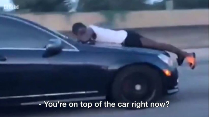 Száguldó autó motorháztetőjéről hívta a rendőrséget - videó