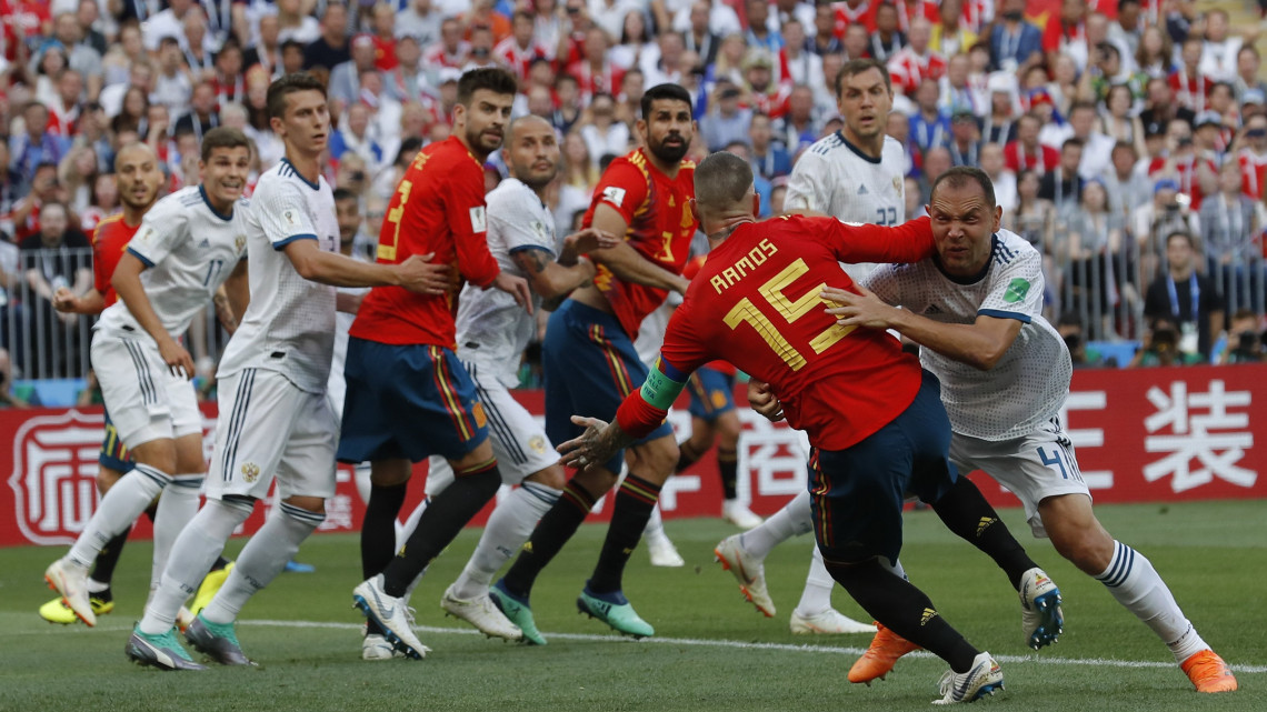 Moszkva, 2018. július 1.Az orosz Szergej Ignasevics (j) a spanyol Sergio Ramosszal birkózik, mielőtt a lábáról saját kapujába pattan a labda az oroszországi labdarúgó-világbajnokság nyolcaddöntőjének Spanyolország  Oroszország mérkőzésén a moszkvai Luzsnyiki Stadionban 2018. július 1-jén.  (MTI/AP/Manu Fernandez)