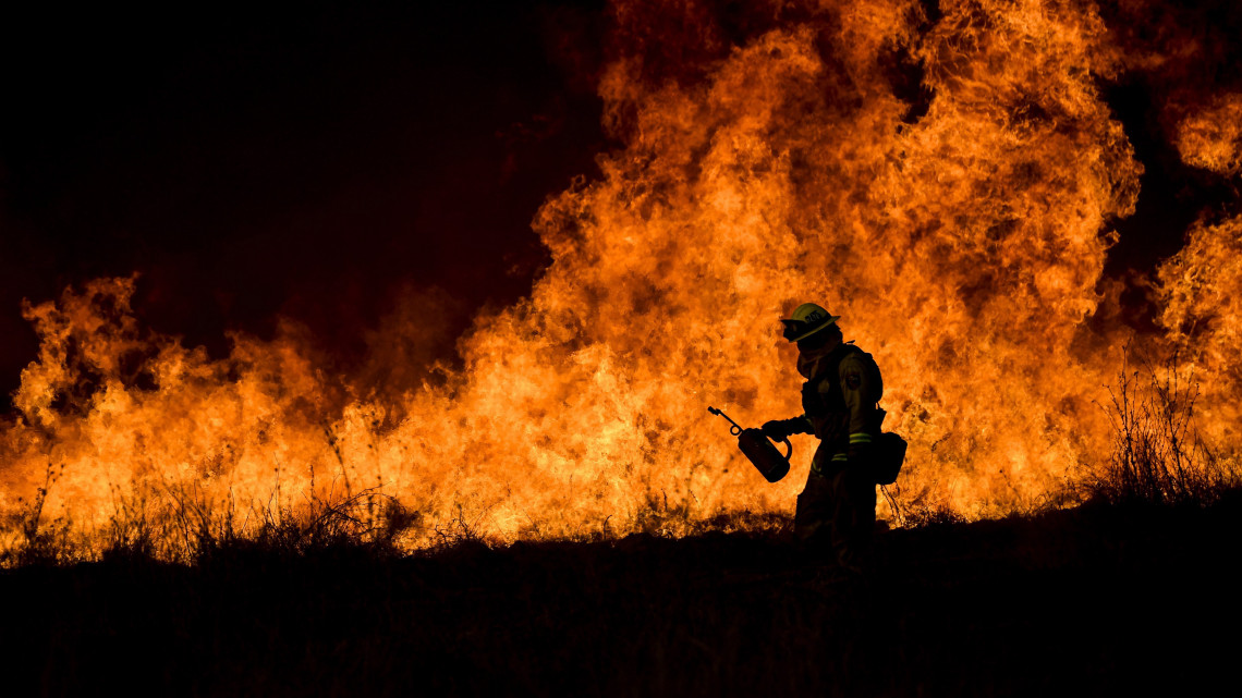 Ojai, 2017. december 10.Tűzoltó a kalifornia Ojai közelében pusztító erdőtűz helyszínén 2017. december 9-én. Eddig több mint 60 ezer hektár vált a lángok martalékává és több százezer embernek kellett elhagynia az otthonát. Donald Trump amerikai elnök két napja szükségállapotot rendelt el Kaliforniában az erdő- és bozóttüzek miatt. (MTI/EPA/John Cetrino)