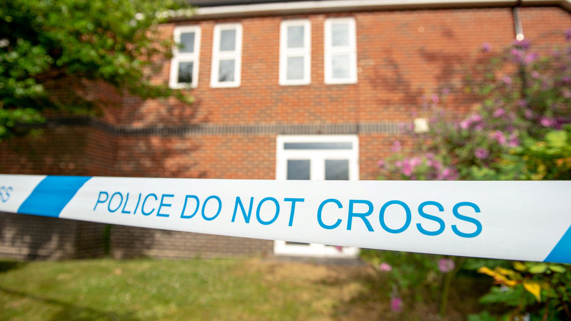 Amesbury, 2018. július 4.Rendőrségi szalaggal körbevont épület a délnyugat-angliai Amesburyben 2018. július 4-én. A kisvárosban három nappal korábban egy férfi és egy nő ismeretlen összetételű anyagtól rosszul lett, állapotuk válságos. A negyvenes éveikben járó két személyt a közeli Salisbury kórházában kezelik. Az ügy vizsgálatába a Scotland Yardnak, a londoni rendőrségnek a terrorelhárító szolgálata is bekapcsolódott. (MTI/EPA/Tony Kershaw)