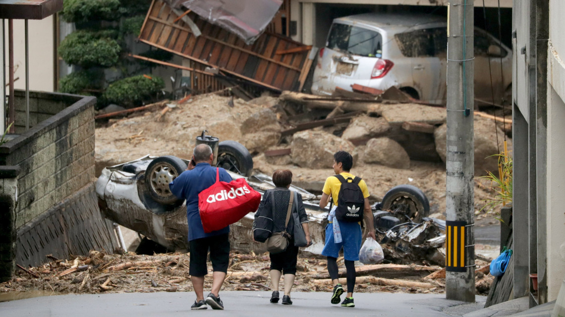 Kurasiki, 2018. július 8.Holmijukat viszik helybeliek az árvíz sújtotta nyugat-japáni Okajama prefektúra Kurasiki városában 2018. július 8-án. A szigetország középső és nyugati részét sújtó árvíz eddig legkevesebb 64 ember halálát okozta, mintegy ötvenen eltűntek. A hatóságok a földcsuszamlás veszélye miatt legalább 2 millió embert szólítottak fel az otthonuk elhagyására. (MTI/EPA/JIJI Press)