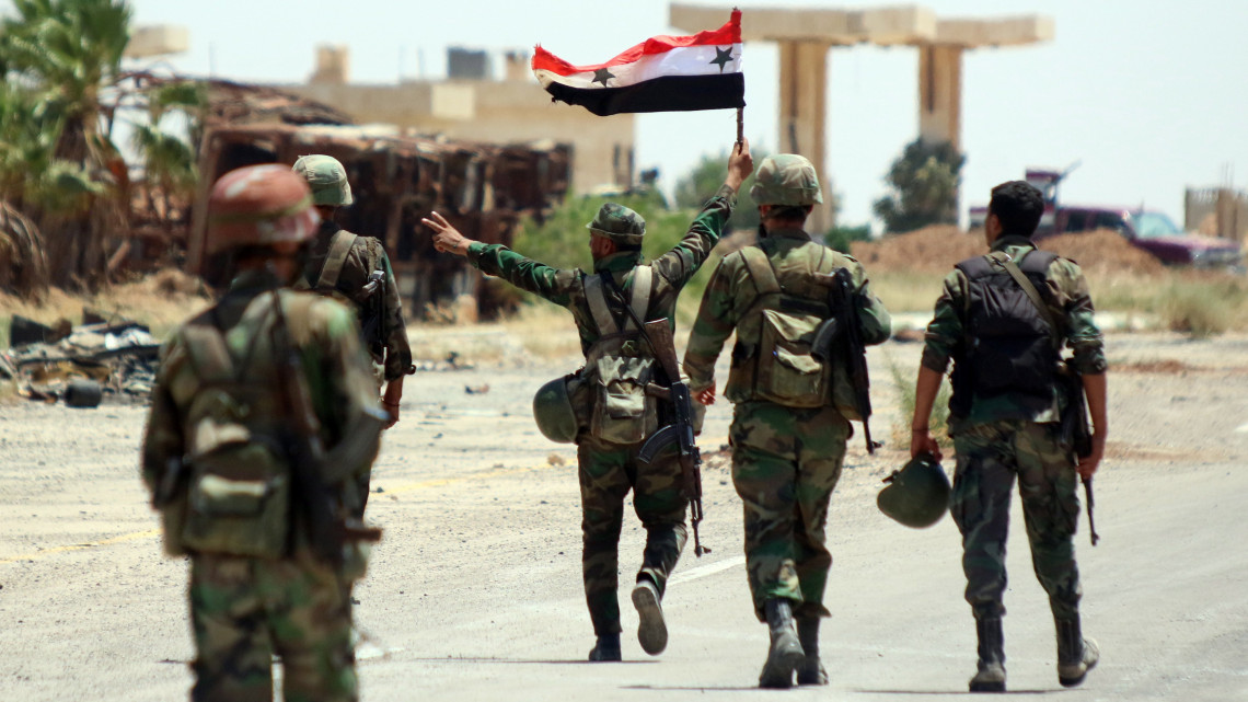 Naszíb, 2018. június 8.Szíriai kormánykatona az ország zászlaját viszi a naszíbi határátkelőnél, a Jordániával szomszédos délnyugat-szíriai Deraa tartományban 2018. július 7-én. A szíriai kormányerők egy nappal korábban visszafoglalták a felkelőktől a stratégiai jelentőségű átkelőt. (MTI/EPA/Juszef Badaui)