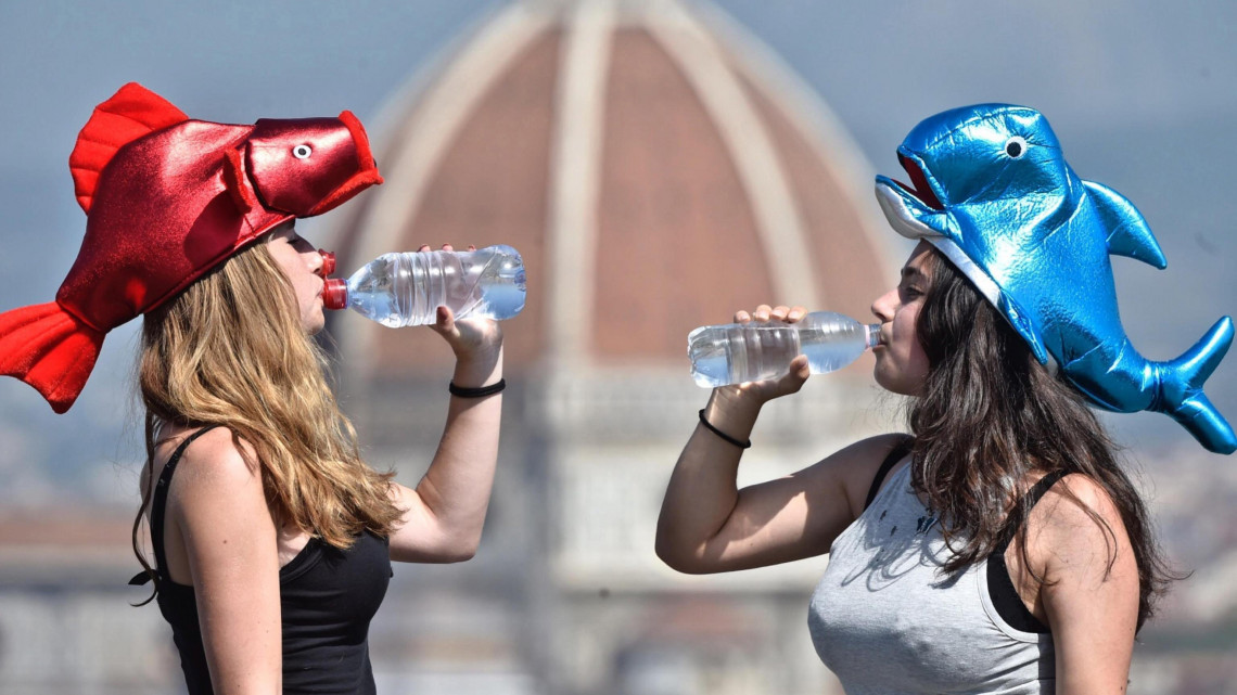 Firenze, 2017. augusztus 1.Halat mintázó fejfedőt viselő lányok frissítőt fogyasztanak Firenzében 2017. augusztus 1-jén. Firenzében akár 40 Celsius-fokot is mérhetnek ezen a napon. (MTI/EPA/Maurizio DeglInnocenti)