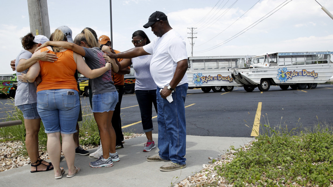 Branson, 2018. július 20.Az áldozatokért imádkoznak gyászolók az üzemeltető cég irodája előtt, a Missouri állambeli Bransonban 2018. július 20-án, miután az előző este a viharos időben felborult, majd elsüllyedt egy kirándulókat szállító kacsahajó a város Table Rock-taván. Legalább tizenhárom ember életét vesztette, négy személyt még keresnek. (MTI/AP/Charlie Riedel)