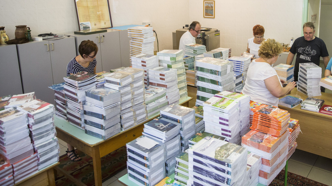Tankönyveket válogatnak az Orosházi Vörösmarty Mihály Általános Iskolában 2017. augusztus 9-én. Az oktatási intézmény 24 osztálya 542 diákjának hétezer tankönyvet szállítottak ki.