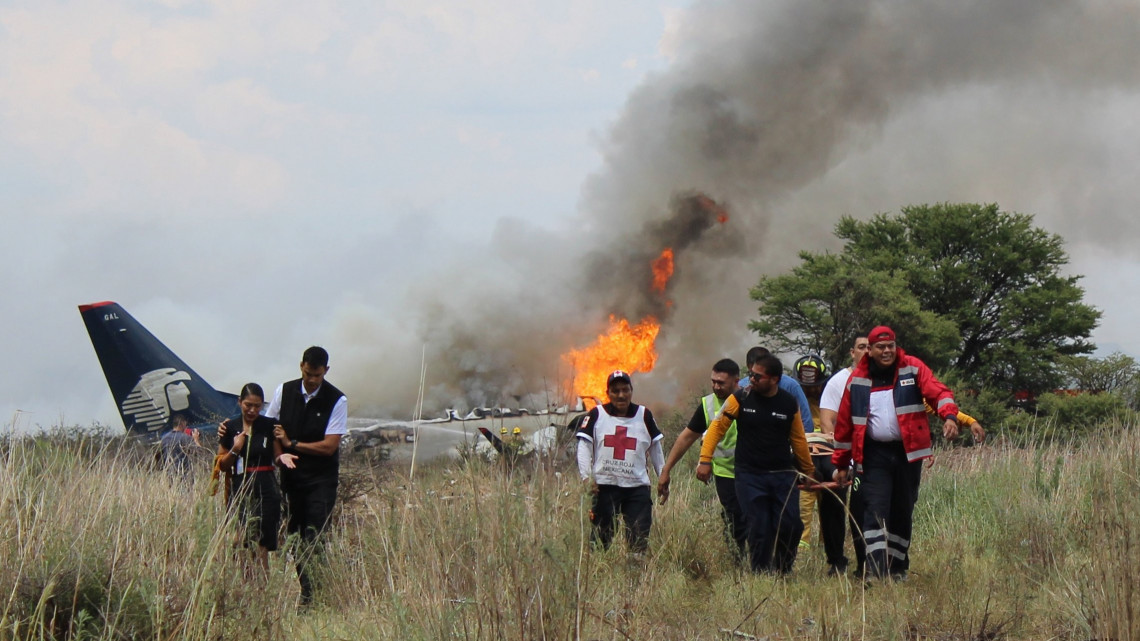 Durango, 2018. augusztus 1.Sebesültet visznek vöröskeresztesek, balról a gép személyzetének két tagja 2018. július 31-én, miután a viharos időben felszállás közben lezuhant, majd kigyulladt az Aeromexico légitársaság repülőgépe a mexikói Durango repülőterének közelében. A fedélzeten kilencvenhét utas és négyfőnyi személyzet tartózkodott, közülük nyolcvanöten sérültek meg, többen súlyosan, de emberéletet nem követelt a baleset. (MTI/AP/Durangói Vöröskereszt)
