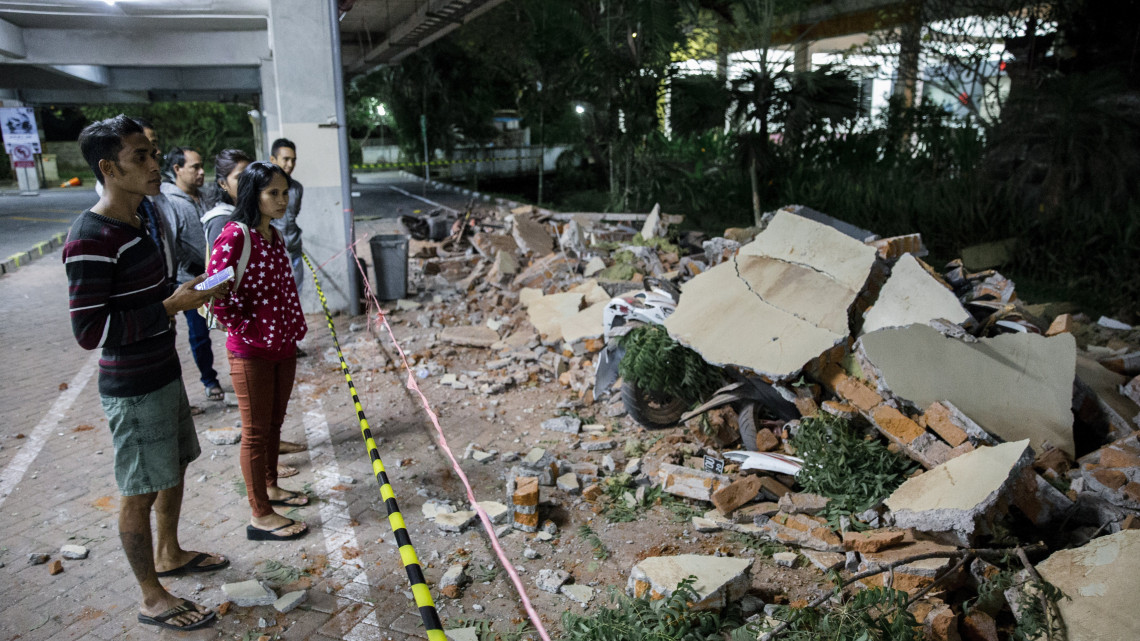 Denpasar, 2018. augusztus 5.Emberek egy földrengéstől megrongálódott bevásárlóközpontnál, az indonéziai Bali szigetén levő Denpasarban 2018. augusztus 5-én. A 7-es erősségű földmozgás epicentrumát a szomszédos Lombok-szigeten mérték 10,5 kilométeres mélységben. A természeti jelenség következtében legkevesebb három ember meghalt Lombokon, ahol számos régi épület megrongálódott. (MTI/EPA/Made Nagi)