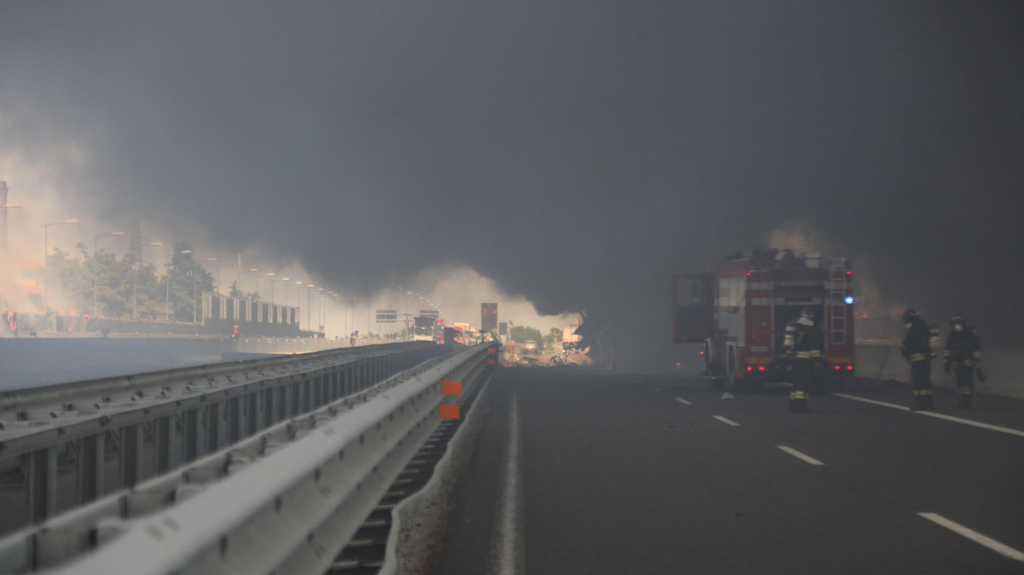 Bologna, 2018. augusztus 6.Sűrű füst gomolyog az autópályán az észak-olaszországi Bologna város repülőtere közelében 2018. augusztus 6-án, miután eddig ismeretlen okból felrobbant egy gyúlékony anyagot szállító tartálykocsi. A jelentések szerint a Borgo Panigale kerületben bekövetkezett detonációnak halálos áldozatai és több tucatnyi sérültje van. (MTI/EPA/Giorgio Benvenuti)