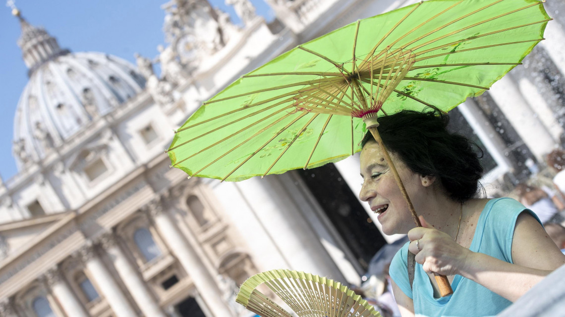 Róma, 2018. augusztus 5.A hőségben legyezi magát egy napernyőt tartó nő a római Szent Péter téren 2018. augusztus 5-én. (MTI/EPA/Claudio Peri)