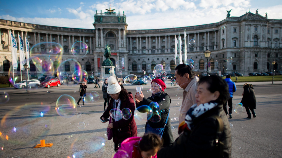 Bécs, 2016. január 26.Egy kínai turistacsoport tagjai szappanbuborékot néznek a bécsi Hofburg-palota előtti Heldenplatzon 2016. január 26-án. (MTI/EPA/Christian Bruna)