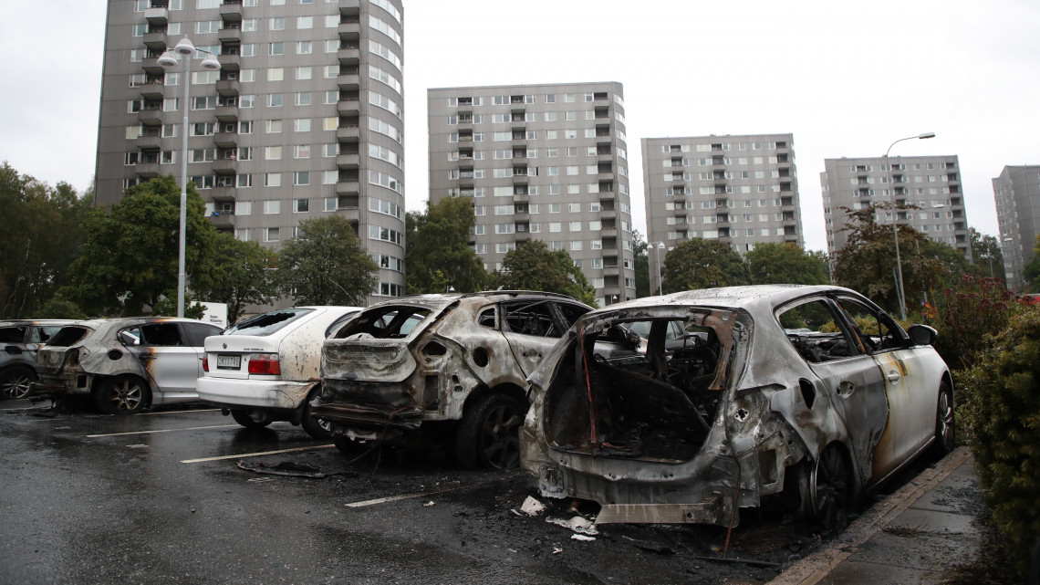 Göteborg, 2018. augusztus 14.Kiégett autók a göteborgi Frolunda téren 2018. augusztus 14-én. Randalírozó fiatalok Göteborgban legkevesebb 88 gépkocsit gyújtottak fel, vagy rongáltak meg. (MTI/EPA/Adam Ihse)