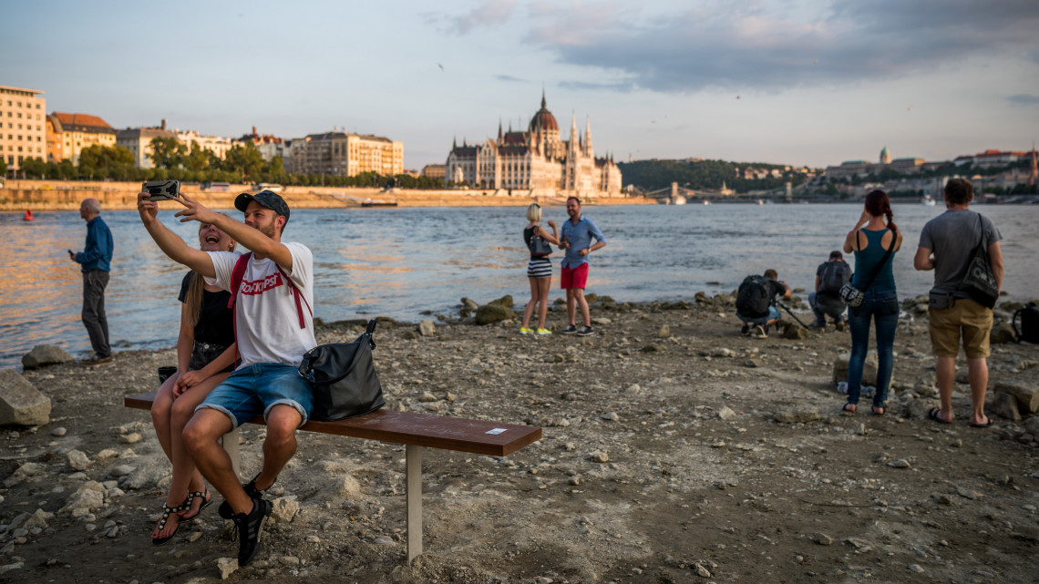 Érdeklődők a Duna partján a budapesti Margit-sziget alacsony vízállásnál járható déli szigetcsúcsánál, a Margit híd középső pillérjénél 2018. augusztus 16-án.