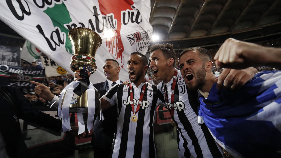 Róma, 2018. május 10. Mehdi Benatia, Mario Mandzukic és Miralem Pjanic, a Juventus játékosai (b-j) ünnepelnek a trófeával, miután csapatuk 4-0-ra győzött az AC Milan ellen a labdarúgó Olasz Kupa döntőjében játszott mérkőzésen Rómában 2018. május 9-én. A címvédő Juventus a fennállása 13. kupagyőzelmét aratta. (MTI/EPA/Ricardo Antimiani)