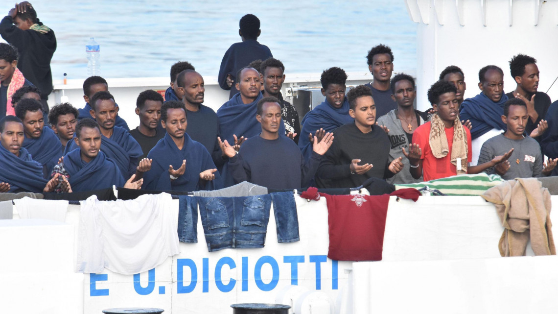 Catania, 2018. augusztus 22.Illegális bevándorlók imádkoznak az olasz parti őrség Diciotti hajójának fedélzetén Catania kikötőjében 2018. augusztus 22-én. Az Európába igyekvő és Málta környékén a Földközi-tengerből kiemelt 177 migráns partra szállását nem engedélyezi Matteo Salvini olasz belügyminiszter, hacsak nem kap garanciát az Európai Uniótól, hogy az utasokat szétosztják a tagállamokban. (MTI/EPA/Orietta Scardino)