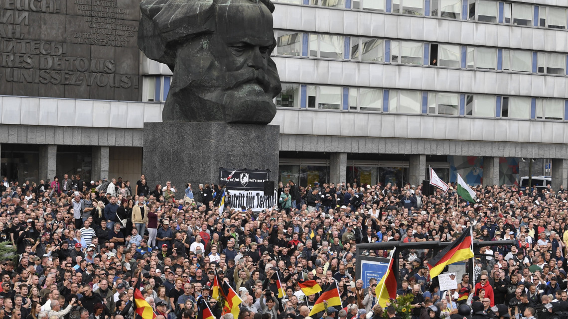 Chemnitz, 2018. augusztus 27.Szélsőjobboldali tüntetők tiltakoznak a kelet-németországi Chemnitzben két nappal ezelőtt történt gyilkosság miatt Karl Marx német filozófus-közgazdásznak, a kommunista eszmék egyik kidolgozójának szobra előtt 2018. augusztus 27-én. A chemnitzi rendőrség és az ügyészség korábban arról tájékoztatott, hogy a belvárosban tartott szabadtéri fesztivál szombati programjai után, éjjel összetűzésbe keveredett egy csoport különböző nemzetiségű férfi. Egy ember életét vesztette, ketten súlyos sebesüléseket szenvedtek. Az emberöléssel egy 23 éves szíriai és egy 22 éves iraki állampolgárt gyanúsítanak.  (MTI/EPA/Filip Singer)