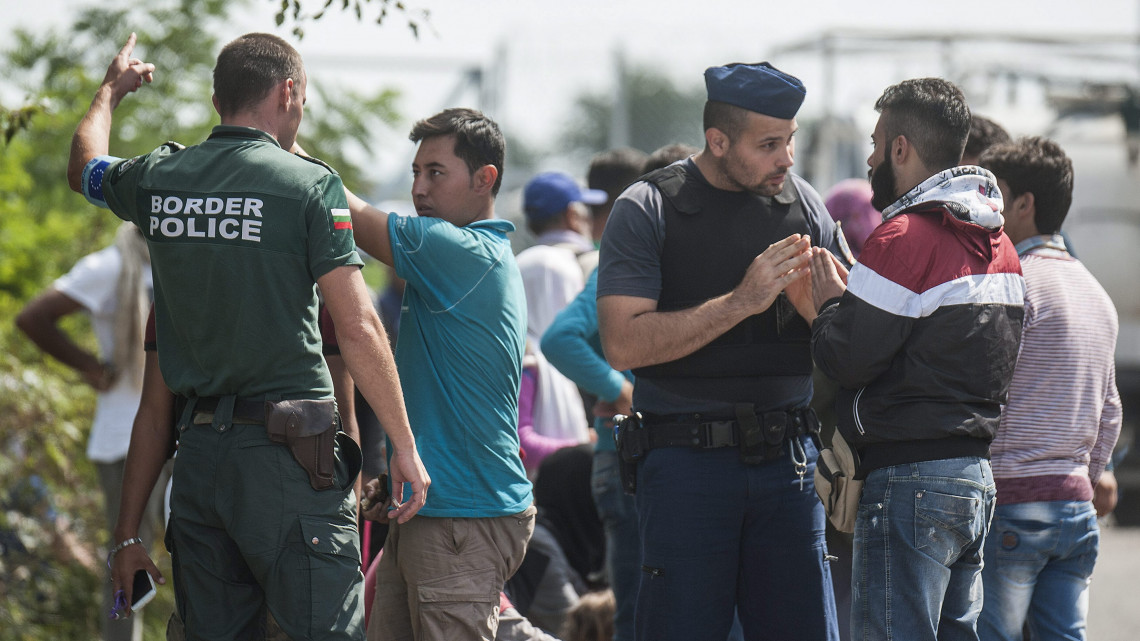 A Frontex bolgár munkatársa (b) és egy magyar rendőr illegális bevándorlókat informál Röszke határában 2015. szeptember 9-én.