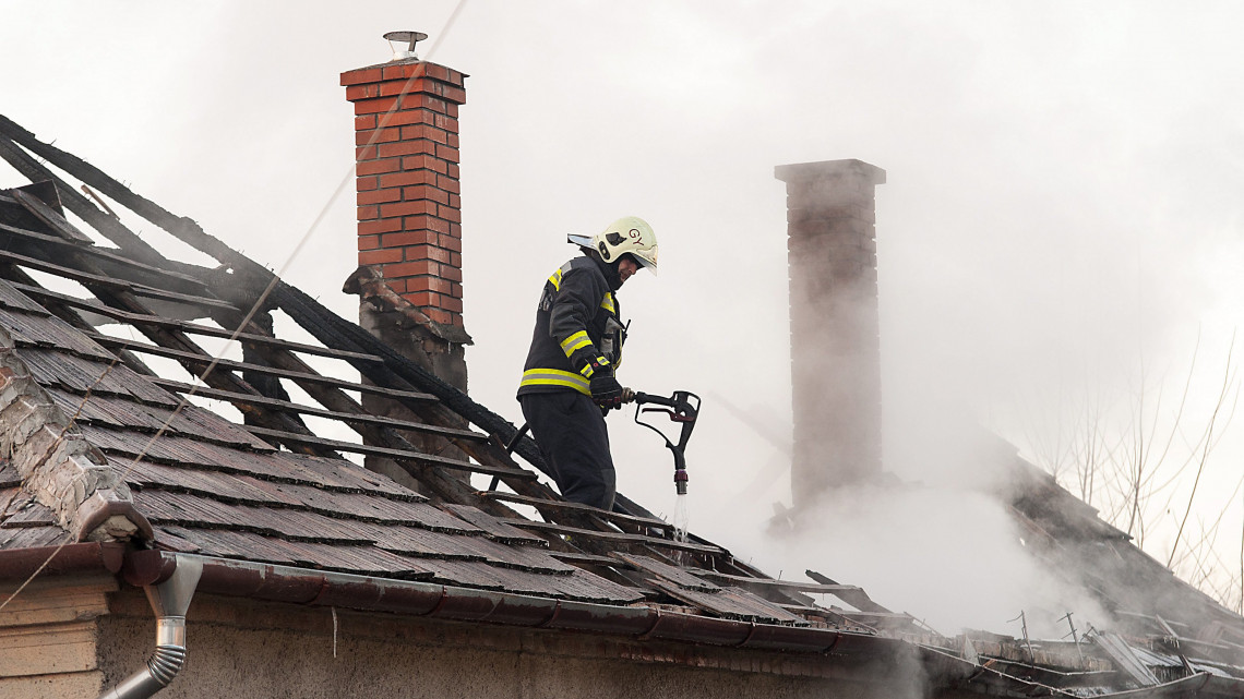 Tűzoltó dolgozik egy kigyulladt családi ház oltásán Győrszentivánban 2017. január 21-én. A tűzben két ember, egy idős nő és egy férfi meghalt.