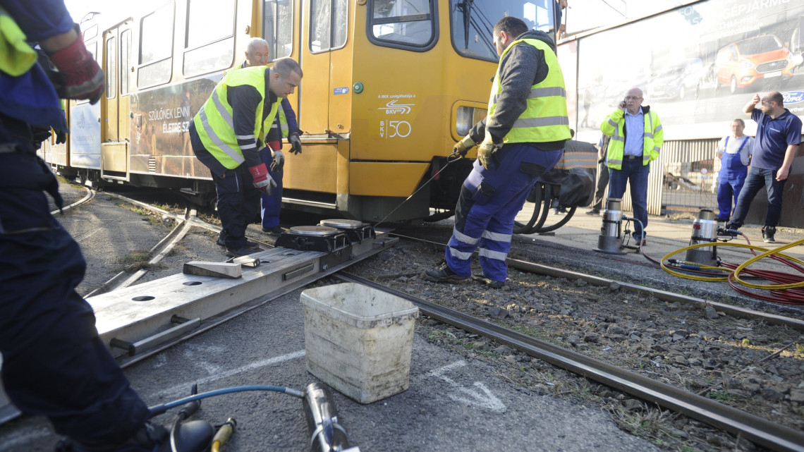 Kisiklott hannoveri villamos visszaemelésén dolgoznak a BKV szakemberei a főváros VIII. kerületében, a Fiumei út és a Salgótarjáni út kereszteződésében 2018. október 9-én.A balesetben nem sérült meg senki.