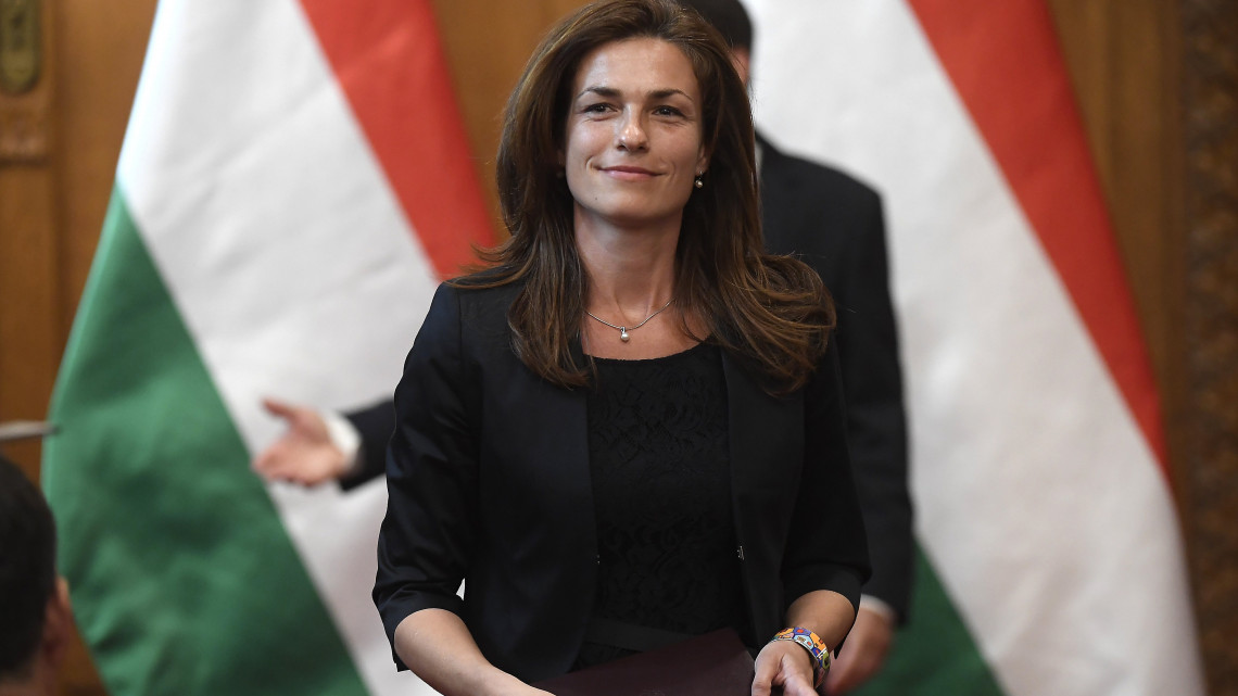 Varga Judit, a Miniszterelnökség államtitkára, miután átvette a kinevezési okmányt Áder János köztársasági elnöktől (hátul) az Országház Vadásztermében 2018. május 22-én.