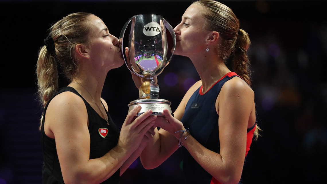 A címvédő Babos Tímea (b) és partnere, a francia Kristina Mladenovic megcsókolja a bajnoki trófeát, miután 6-4, 7-5-re győztek a Barbora Krejcikova, Katerina Siniakova alkotta cseh kettős ellen a hétmillió dollár (2 milliárd forint) összdíjazású szingapúri női tenisz-világbajnokság páros versenyének döntőjében 2018. október 28-án.