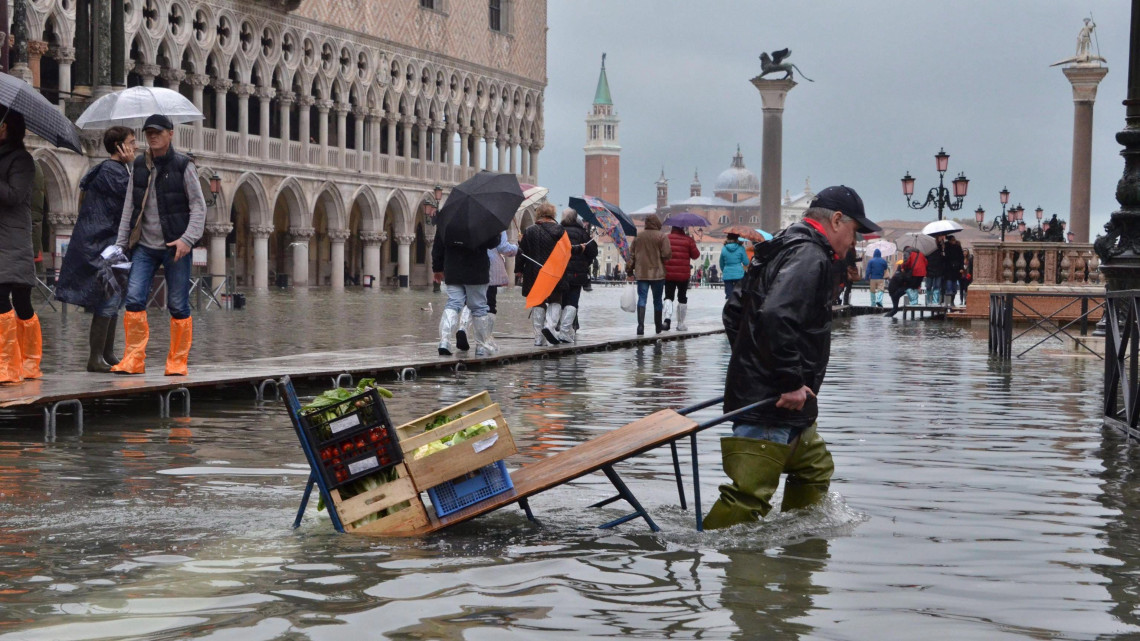Velence, 2013. november 19.Egy zöldséges húzza a kocsiját a vízben álló velencei Szent Márk téren 2013. november 19-én, miután a vízszint magassága 124 centiméterre emelkedett a városban. (MTI/EPA/Andrea Merola)