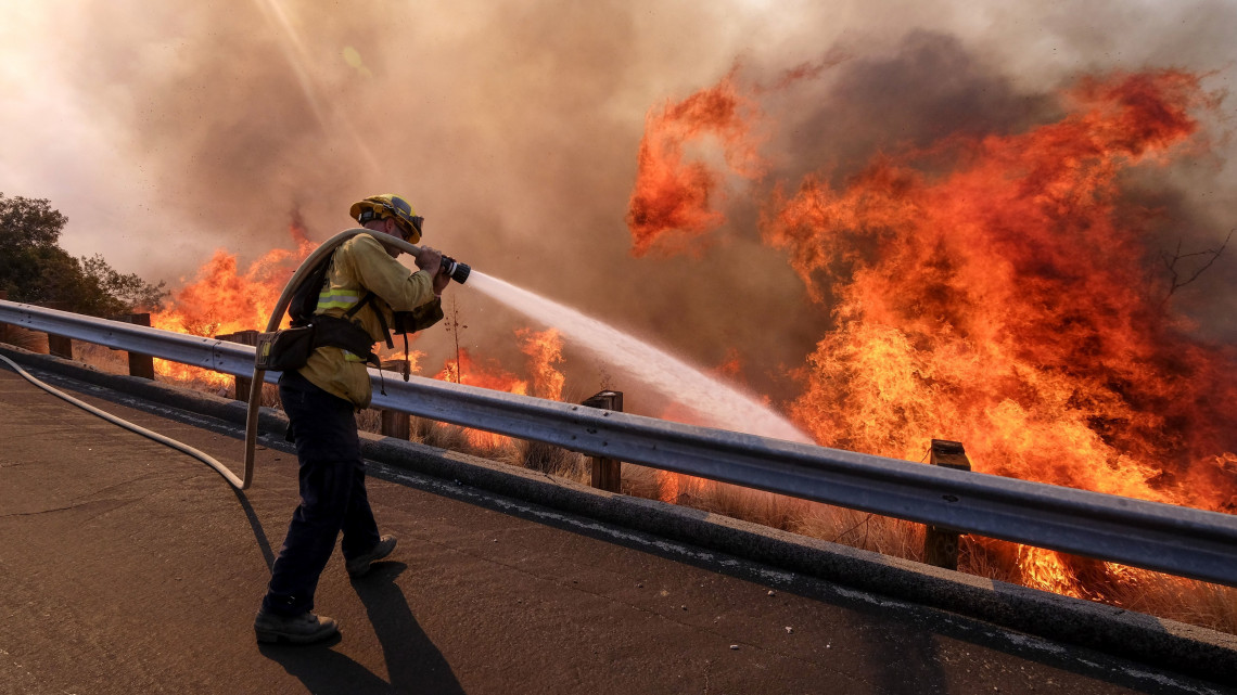 Tűzoltó küzd a lángok megfékezésén a kaliforniai Simi Valley környékén pusztító erdőtűz helyszínén 2018. november 12-én. Az egy hete kitört kaliforniai tűzvész eddig legkevesebb 31 halálos áldozatot követelt, az eltűntek száma meghaladja a kétszázat.