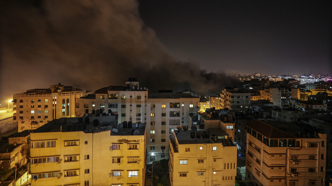 Füst száll fel egy találatot kapott épületből, amint az izraeli légierő rakétákkal támadja Gáza palesztin várost 2018. november 12-én. Fél nap alatt közel háromszázhetven rakétát indítottak a palesztin Gázai övezetből izraeli településekre, Izrael ugyanakkor mintegy százötven csapást mért a Gázai övezetet irányító Hamász radikális iszlamista szervezet célpontjaira.