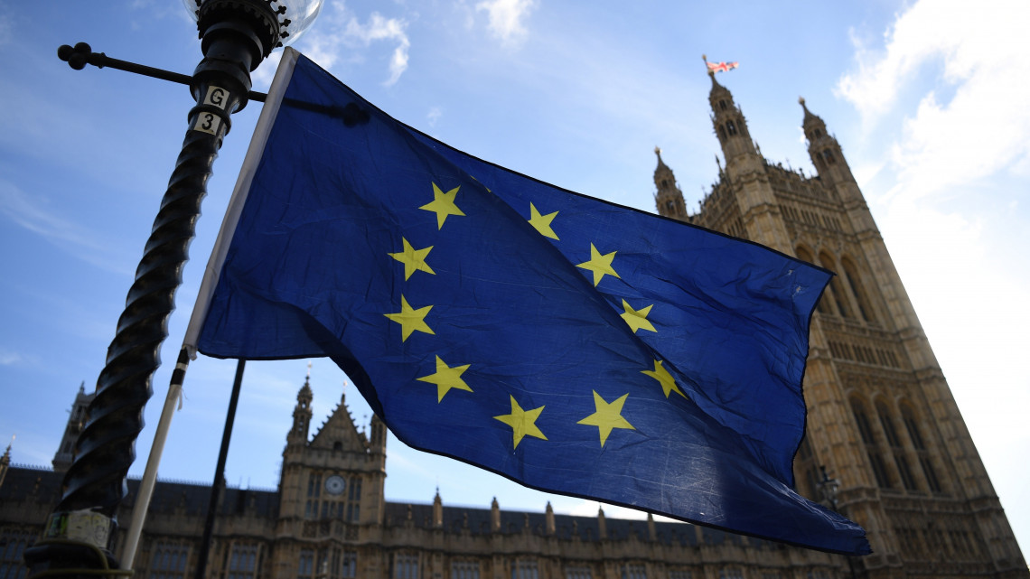 Az Európai Unió zászlaja a brit parlament épülete előtt 2018. október 18-án. Theresa May brit miniszterelnök az EU-tagországok állam- és kormányfőinek brüsszeli csúcstalálkozója második napi tanácskozása előtt úgy nyilatkozott, hogy elképzelhetőnek tartja az országa uniós kilépését követő, eredetileg 2020 végéig tervezett átmeneti időszak néhány hónapos meghosszabbítását.