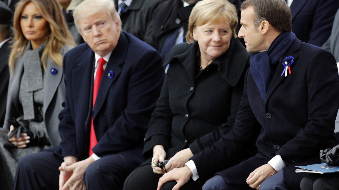Emmanuel Macron francia elnök Angela Merkel német kancellár lábára teszi a kezét, mellettük Donald Trump amerikai elnök és a felesége, Melania Trump az első világháborút lezáró fegyverszüneti egyezmény 100. évfordulójának alkalmából rendezett ünnepségen a párizsi diadalívnél 2018. november 11-én.
