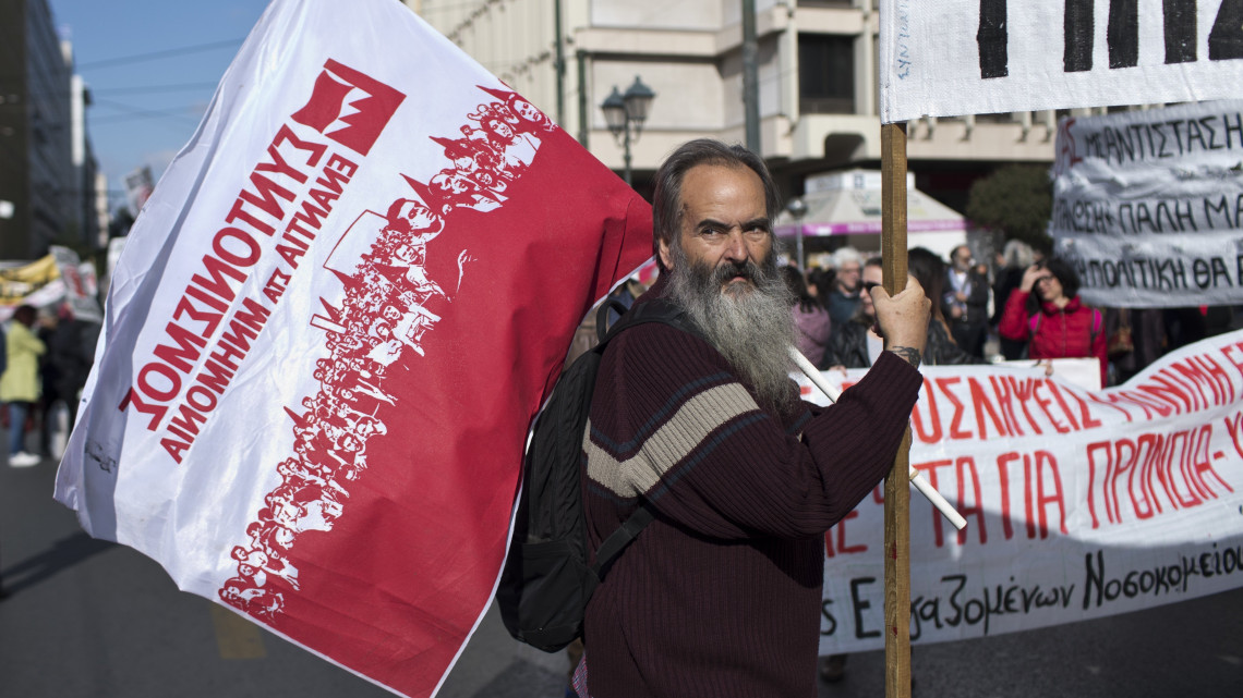 Zászlót tartó tüntető a görög közszféra dolgozóinak bér- és nyugdíjemelést követelő 24 órás munkabeszüntetése idején Athénban 2018. november 14-én.