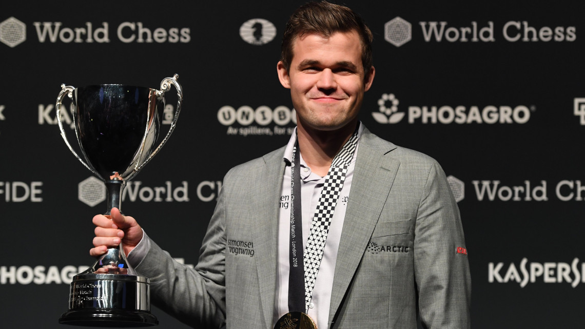 A címvédő győztes norvég Magnus Carlsen a bajnoki trófeával, miután rapid partikban 3-0-ra győzött az olasz-amerikai kihívója, Fabiano Caruana ellen a sakkvilágbajnoki döntőben Londonban 2018. november 28-án.