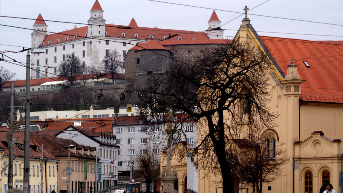 A Kapucinus utca részlete a történelmi belvárosban. Jobbra a kapucinusok temploma, a háttérben a pozsonyi vár négy saroktornyos főépülete az erődrendszer részletével.