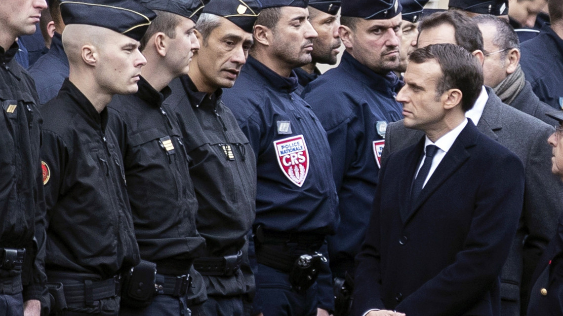 Emmanuel Macron francia elnök (j) rendőrökkel beszélget a dráguló üzemanyagárak ellen tiltakozó sárgamellényesek zavargásba torkolló tüntetése utáni napon a párizsi Diadalívnél 2018. december 2-án. Párizs belvárosának legelegánsabb részében a tüntetők autókat gyújtottak fel, épületeket rongáltak meg, kirakatokat fosztottak ki és utcakövekből emeltek barikádokat.