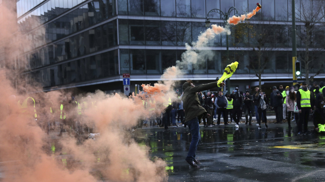A belga kormány gépjárműveket érintő adópolitikája, valamint a fűtőolaj és az elektromos áram magas ára miatt tiltakozó sárgamellényes tüntetők egyike egy tárgyat dob a rendőrök felé Brüsszelben 2018. december 8-án.