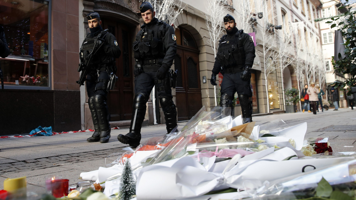 Rendőrök érkeznek a strasbourgi lövöldözés áldozatainak rögtönzött belvárosi emlékhelyéhez 2018. december 13-án. Két nappal korábban Chérif Chekatt, egy iszlamista hátterű férfi a strasbourgi karácsonyi vásáron tüzet nyitott a járókelőkre, majd elmenekült a helyszínről. A támadásban hárman meghaltak, tizenketten megsebesültek, közülük hatan kritikus állapotban vannak.