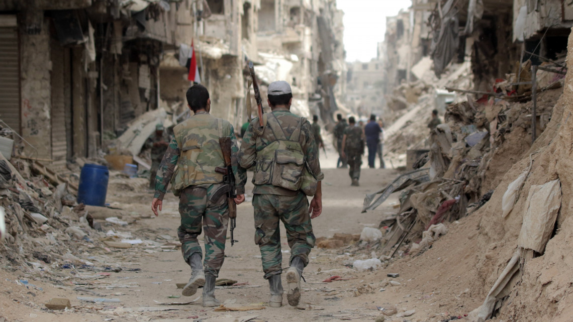Jarmúk menekülttábor, 2018. május 22. Szíriai kormánykatonák járőröznek a Damaszkusztól délre fekvő Jarmúk palesztin menekülttábor közelében 2018. május 22-én, miután az előző napon a szíriai hadsereg kiszorította az Iszlám Állam (IÁ) terrorszervezet dzsihadistáit a Damaszkusztól délre fekvő al-Hadzsár el-Aszuád körzetből. A szíriai hadsereg és szövetségesei hetek óta harcoltak az al-Hadzsár el-Aszuád-i terület és a szomszédos Jarmúk palesztin menekülttábor visszafoglalásáért, a főváros melletti utolsó területért, amely még az IÁ kezén volt. (MTI/EPA/Juszef Badaui)