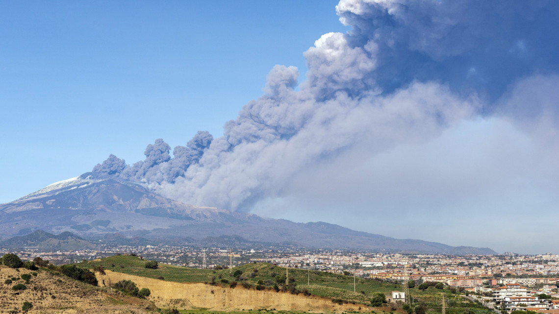 Füst gomolyog az Etnából a szicíliai Catania közelében 2018. december 24-én, kevéssel a tűzhányó kitörése előtt. A rossz látási viszonyok miatt lezárták a cataniai repülőteret. A kitörést követő földmozgások legnagyobbika 4-es erősségű volt, sérültekről nem érkezett jelentés.