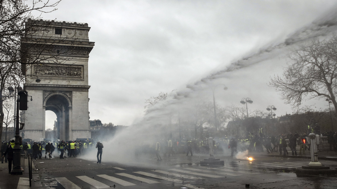 Vízágyúval oszlatják rendőrök a francia kormány szociális és adópolitikája ellen tiltakozó sárgamellényesek tüntetését a párizsi diadalívnél 2019. január 12-én. A kormányellenes tüntetések kilencedik egymást követő hétvégéjén a hatóságok a biztonsági erők mintegy 80 ezer tagját vetették be Franciaország-szerte.