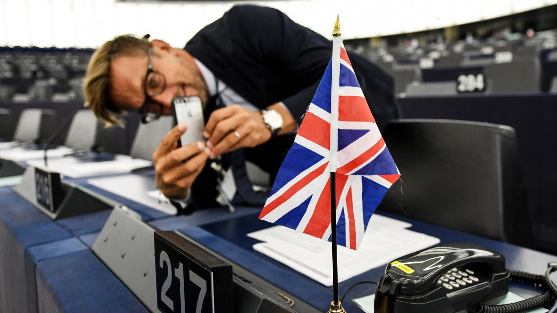 Brit nemzeti színű zászlót fényképez egy férfi a brit EU-tagság megszűnéséről (Brexit) folytatott vita előtt az Európai Parlament üléstermében, Strasbourgban 2019. január 16-án. Előző nap a brit alsóház 230 szavazat többséggel elutasította a  kormány és az Európai Unió közötti Brexit-megállapodást.