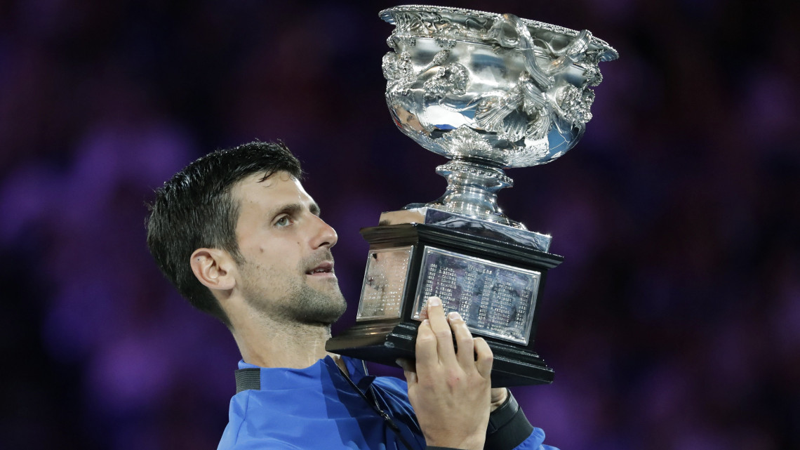 A szerb Novak Djokovic ünnepel a trófeával, miután legyőzte a spanyol Rafael Nadalt a melbourne-i ausztrál nyílt teniszbajnokság férfi egyesének döntőjében 2019. január 27-én.