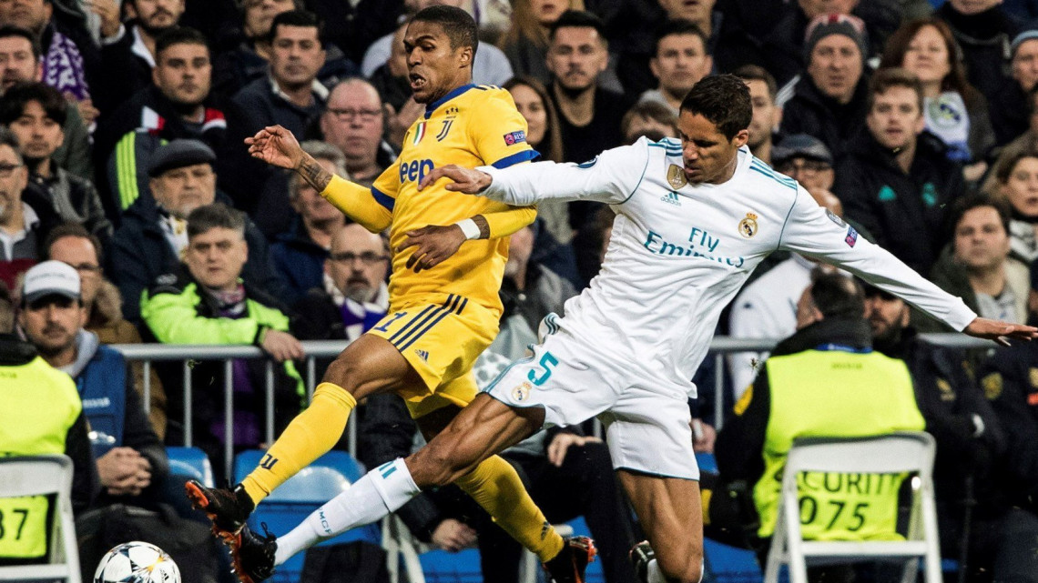 Raphael Varane, a Real Madrid (j) és Douglas Costa de Souza, a Juventus játékosa a labdarúgó Bajnokok Ligája negyeddöntőjének visszavágó mérkőzésén a madridi Santiago Bernabeu stadionban 2018. április 11-én.