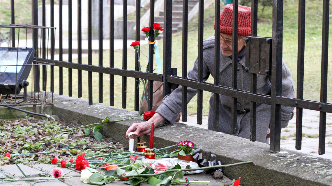 Idős nő gyertyát gyújt a marosvásárhelyi székely vértanúk emlékművénél 2015. március 10-én. Az erdélyi város polgármesteri hivatala megtiltotta a székely vértanúk 1854-es kivégzésének évfordulójára, a Székely szabadság napjára tervezett felvonulást.