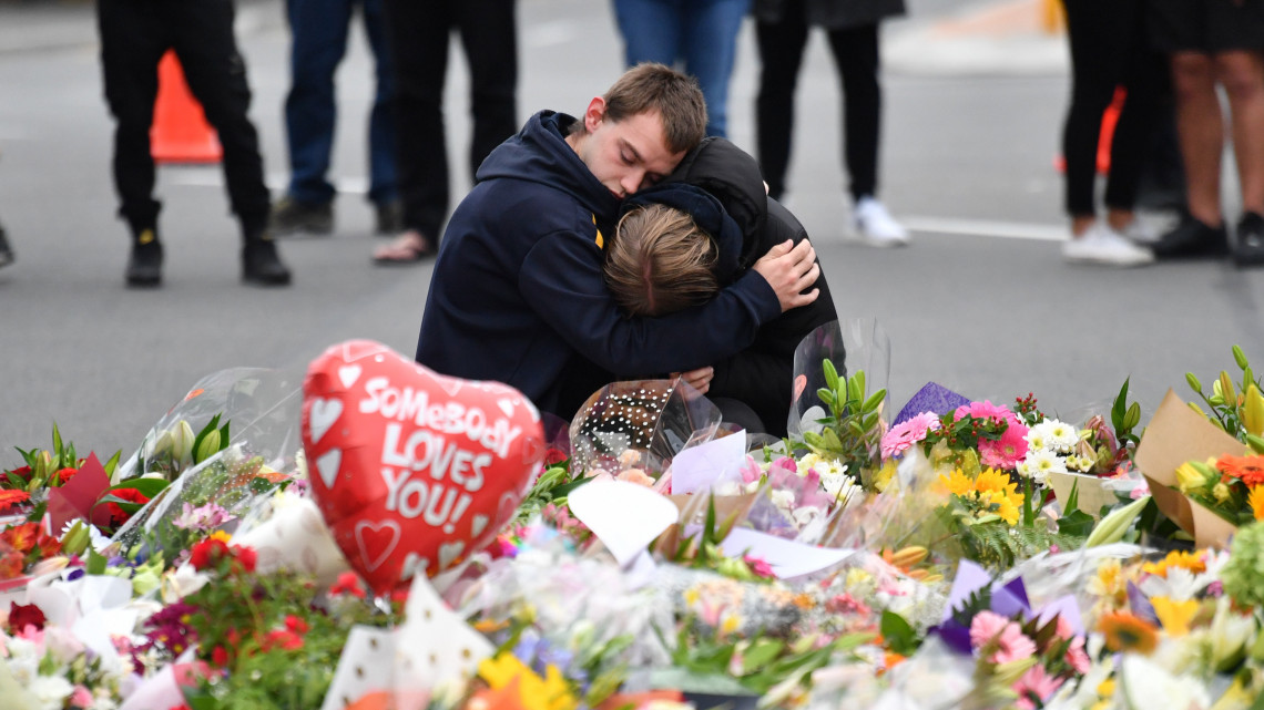 Gyászolók az új-zélandi Christchurchben elkövetett két terrortámadás 49 halálos áldozatának rögtönzött emlékhelyén 2019. március 16-án, a merényletek másnapján. A város központjában levő Maszdzsid al-Núr és a külső kerületi Linwood mecset ellen elkövetett összehangolt támadásban 48-an megsebesültek. A hatóságok őrizetbe vettek három férfit és egy nőt. A fő gyanúsított, a 28 éves ausztrál Brenton Tarrant ellen tömeggyilkosság miatt vádat emeltek.