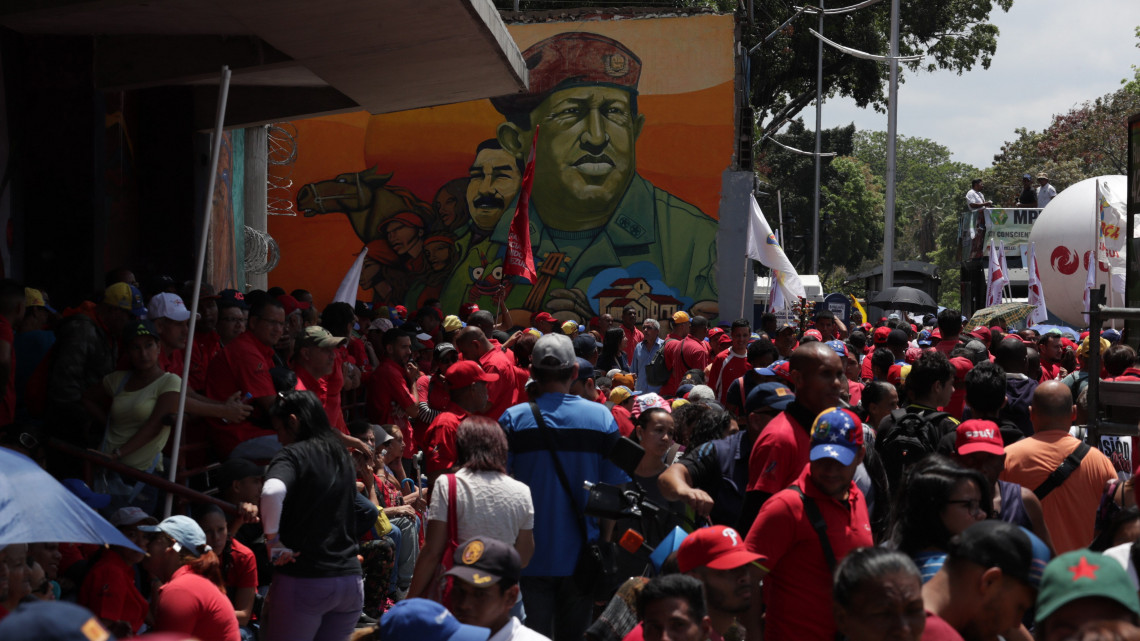 Nicolás Maduro venezuelai elnök támogatói tüntetnek Hugo Chávez néhai venezuelai államfő óriásplakátjaval Caracasban 2019. március 23-án. Juan Guaidó, a venezuelai parlament elnöke 2019. január 23-án ideiglenes államfővé nyilvánította magát. Eddig az Egyesült Államok és mintegy ötven nyugati ország ismerte el Guaidót Venezuela vezetőjének.