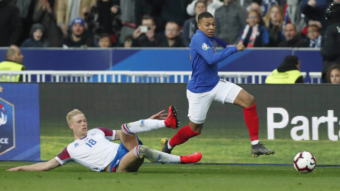 A francia Kylian Mbappé (j) és az izlandi Hördur Magnússon a labdarúgó Európa-bajnoki selejtező H csoportjában játszott Franciaország - Izland mérkőzésen Saint-Denis-ben 2019. március 25-én.