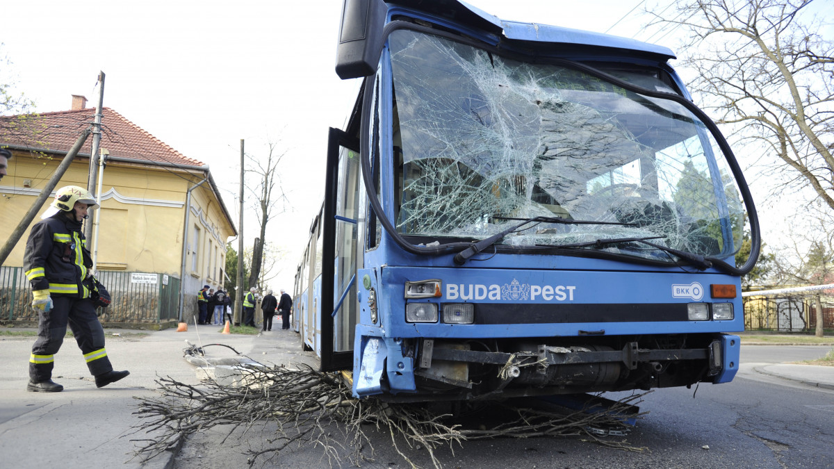Összetört busz mellett dolgozik egy tűzoltó a XVIII. Darányi Ignác utca és Reviczky Gyula utca kereszteződésénél 2019. április 4-én, miután a jármű eddig tisztázatlan körülmények között összeütközött egy autóval. A busz kidöntött egy villanyoszlopot és egy parkoló autónak ütközött, az elsődleges információk szerint a balesetben nem sérült meg senki.