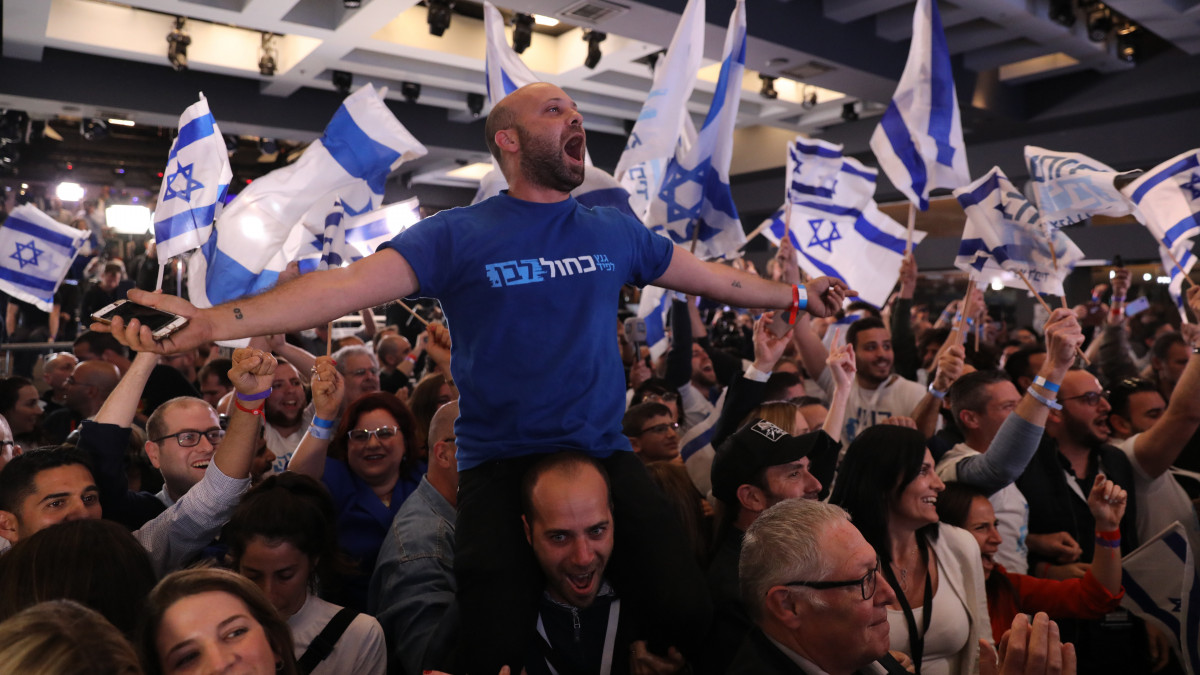 A Kék-fehér párt támogatói ünnepelnek a párt tel-avivi központjában 2019. április 9-én, az előrehozott izraeli parlamenti választások napján. Az első becslések szerint a jelenleg kormányzó Likud és a Kék-fehér párt fej fej mellett végzett a választáson.