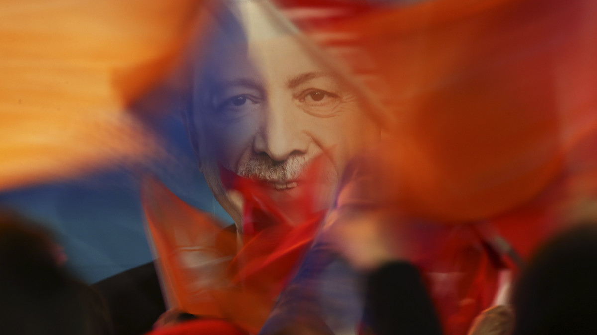 Recep Tayyip Erdogan török államfő, a kormányzó Igazság és Fejlődés Párt (AKP) vezetőjét ábrázoló transzparens előtt lengetik a párt zászlóit az AKP isztambuli főpolgármester-jelöltjének, Binali Yildirim volt kormányfőnek a támogatói a helyhatósági választások napján, 2019. március 31-én Isztambulban.