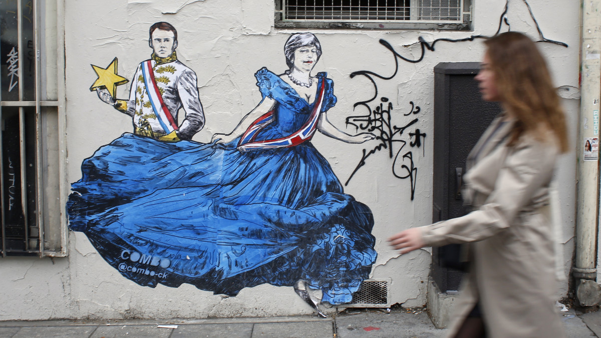 A Combo nevű francia művész Theresa May brit miniszterelnököt (j) és Emmanuel Macron francia államfőt ábrázoló falfestménye Párizsban 2019. április 9-én.